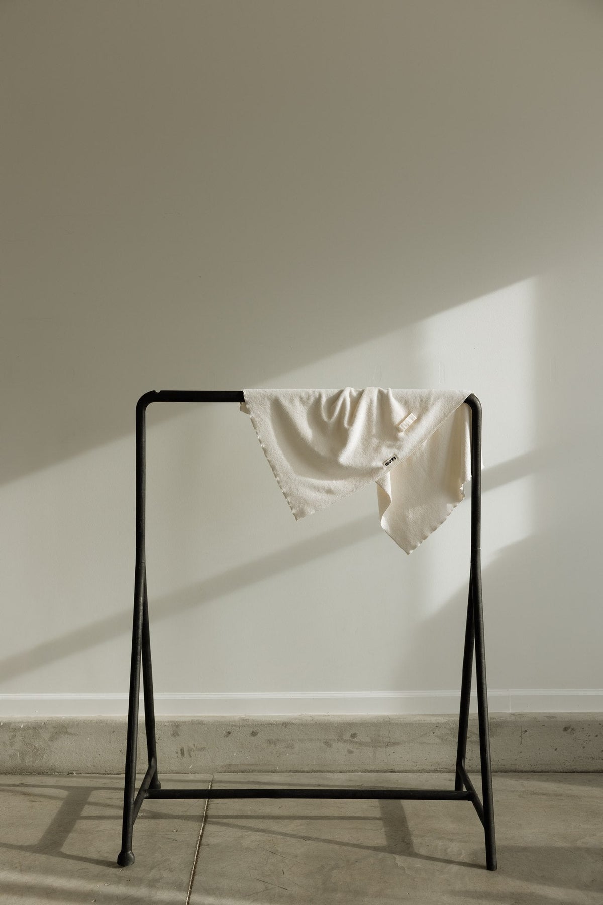 COTI hair towel draped over a minimal metal drying rack