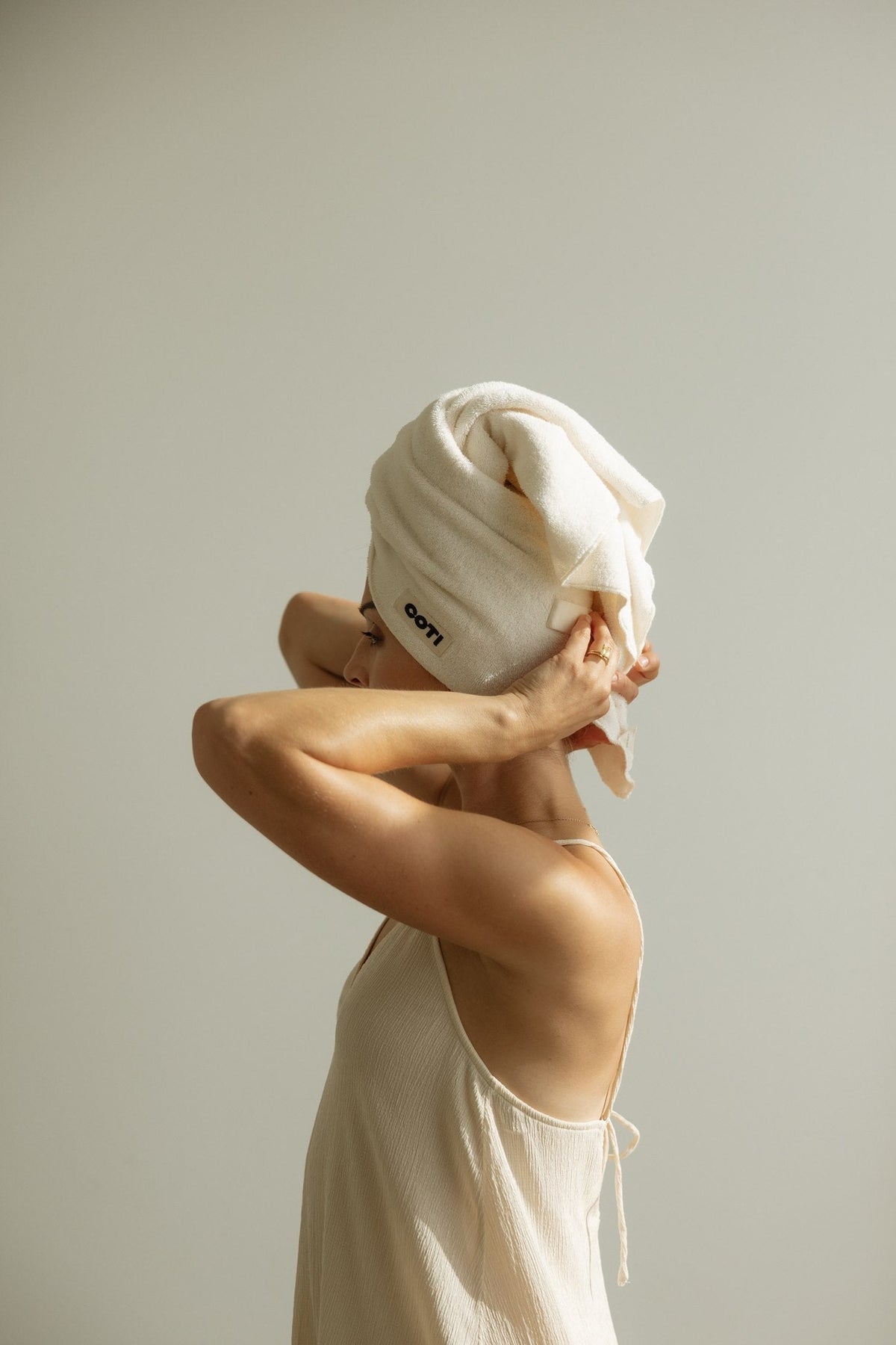 Woman wrapping wet hair in a cotton terry hair towel