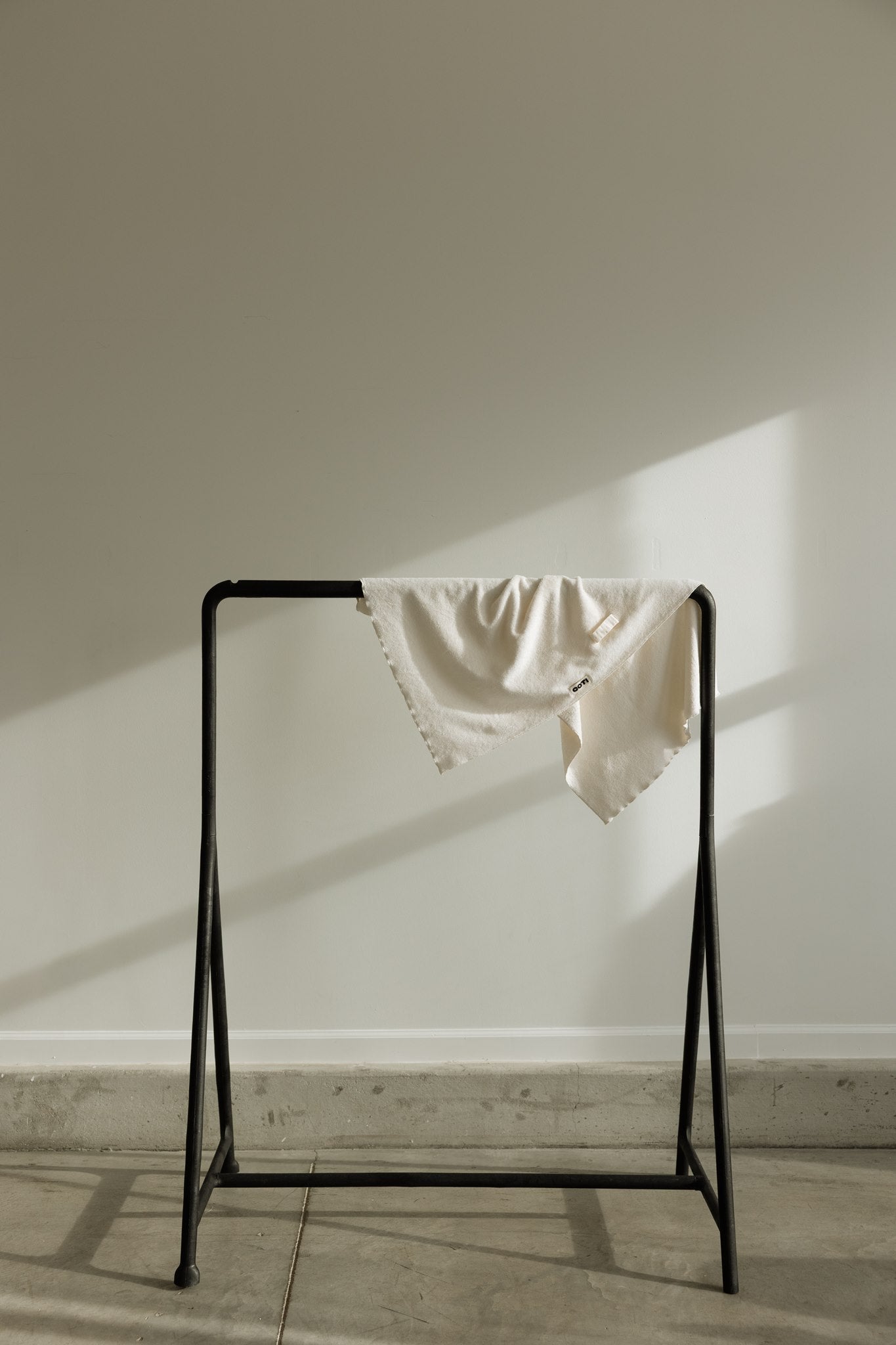 COTI hair towel draped over a minimal metal drying rack
